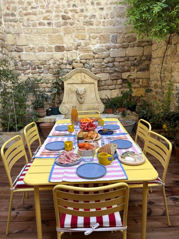 a yellow table with plates of food on it at Plumard in Arles