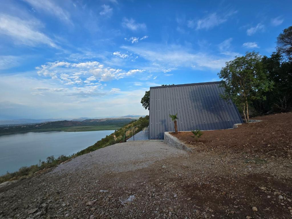 a building on a hill next to a body of water at The Quiet Wild in Briska Gora