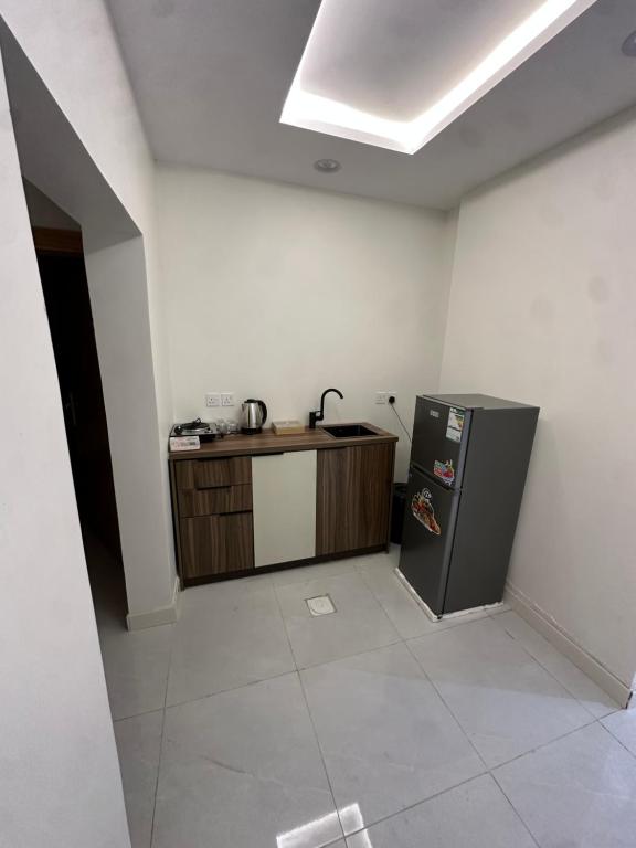 a kitchen with a counter and a refrigerator in a room at شقق تأجير يومي in Musaylah