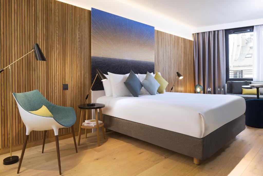 ein Hotelzimmer mit einem Bett und einem Stuhl in der Unterkunft Drawing Hotel in Paris