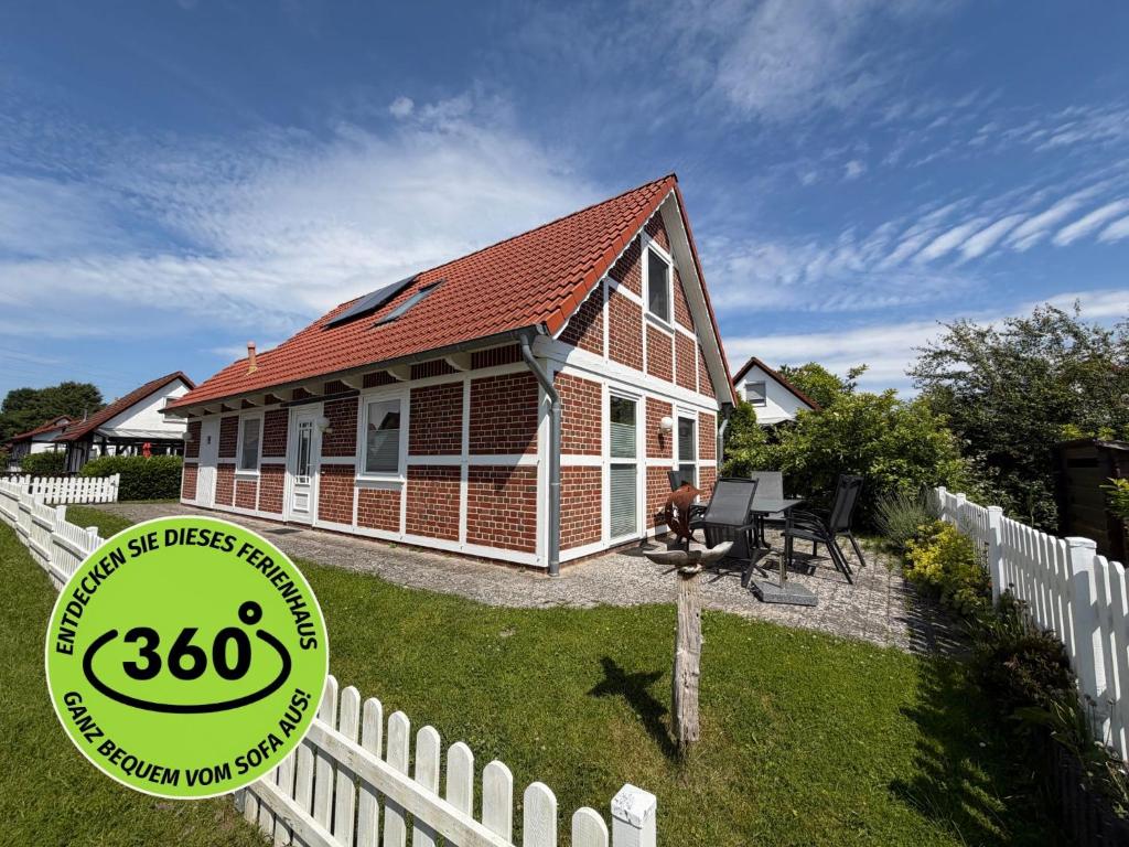 a small house with a sign in front of it at Premium-Ferienhaus Ingrid Marie im Feriendorf Altes Land an der Elbe in Hollern-Twielenfleth