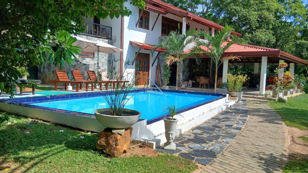 a swimming pool in front of a house at Machan Villa in Tangalle