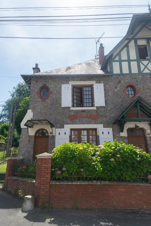 a large brick house with a hedge in front of it at l atelier des etoiles in Haybes
