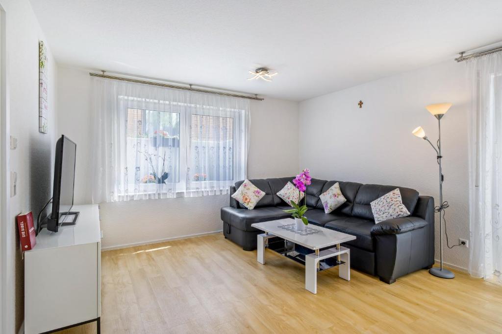 a living room with a black couch and a table at Apartment Dußlingen in Dußlingen