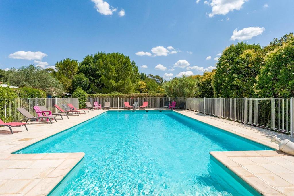 a swimming pool with chairs and a fence at Gite les Mazets du Rouret in Saint-Christol-lès-Alès