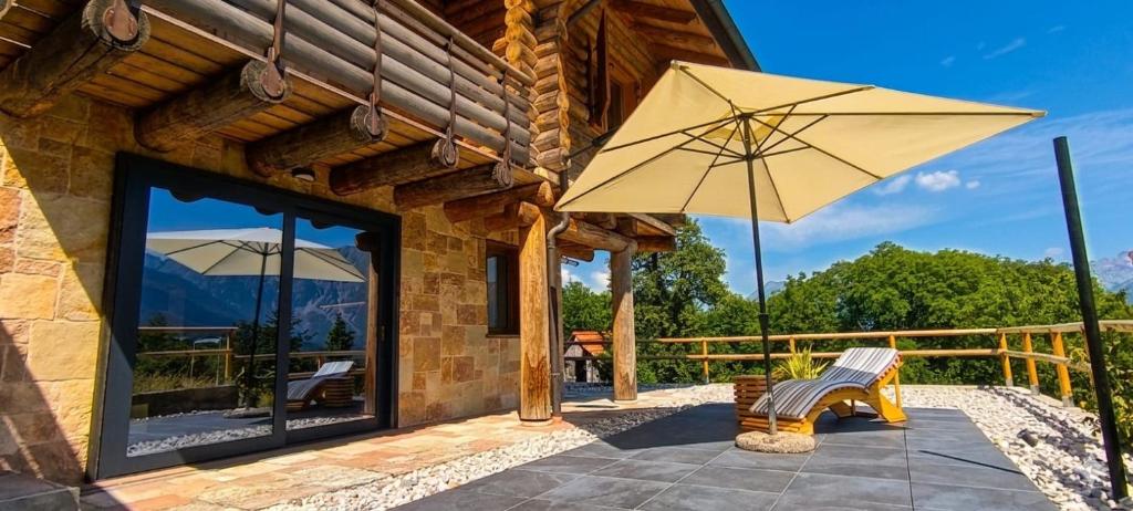 a patio with a bench and an umbrella at DolomitiBel Siberiana 2 SILVER in Braz