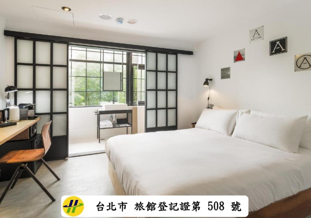 a bedroom with a white bed and a desk and a window at ART'OTEL Ximending TAIPEI in Taipei