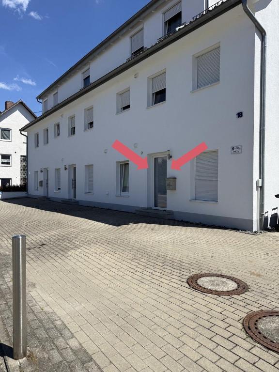 a white building with red arrows on the side of it at Team at Home Senden W2 in Senden