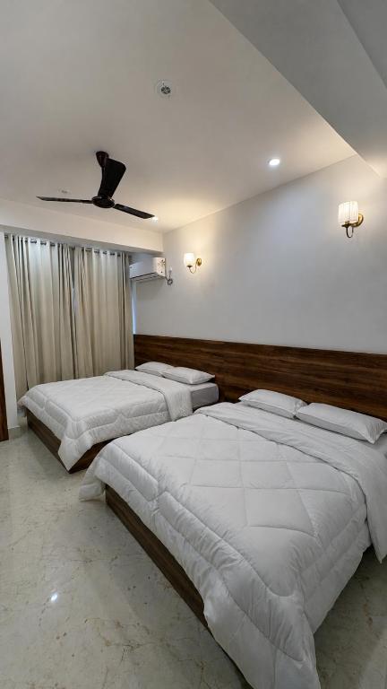 a bedroom with two beds and a ceiling at Vortex Suites in Guwahati