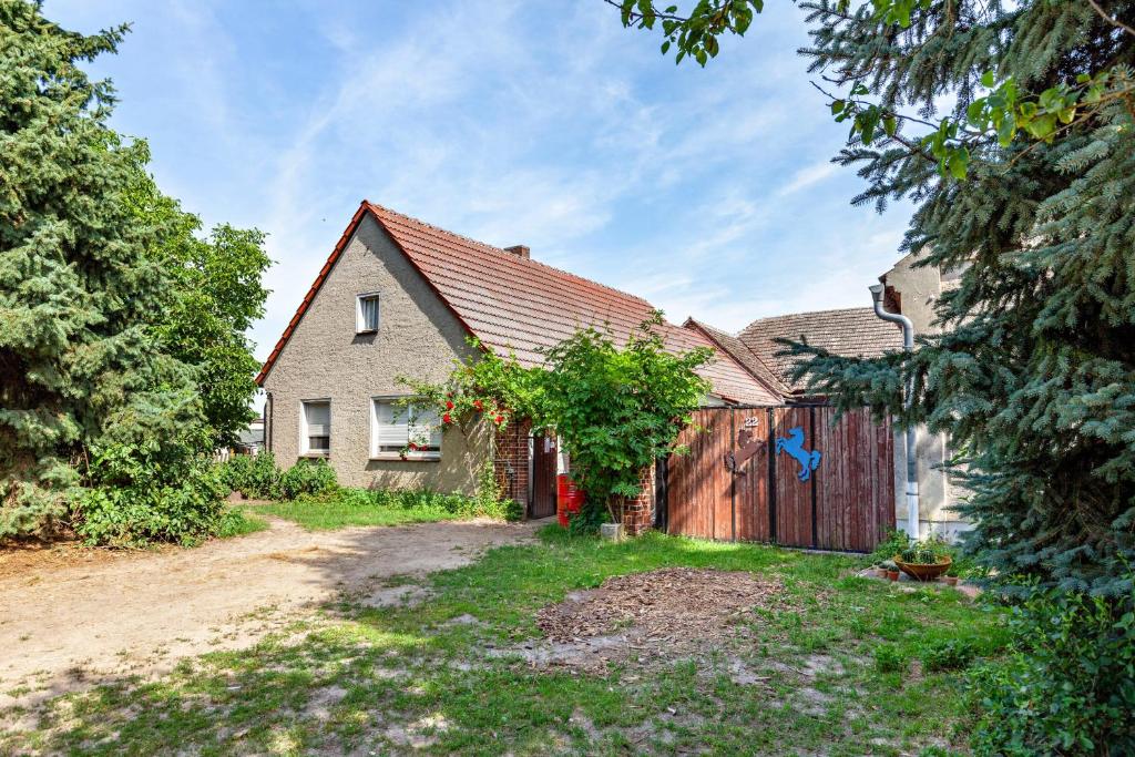 a house with a wooden fence in the yard at Ponyhof Kudowa in Sonnewalde
