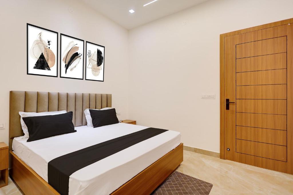 a bedroom with a bed and a wooden door at Hotel O Grace in Hānsi