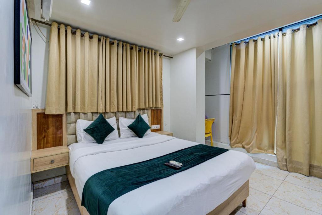 a bedroom with a large bed and a window at Hotel Elmas in Bangalore