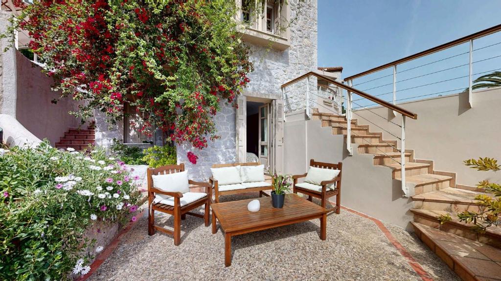 a patio with chairs and a table and a staircase at Epidavros Villas Voukamvilia Retreat, Shared Pool in Nea Epidavros