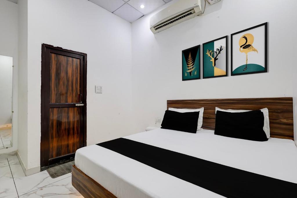 a bedroom with a bed and some pictures on the wall at Hotel O JIND RESORT in Jīnd