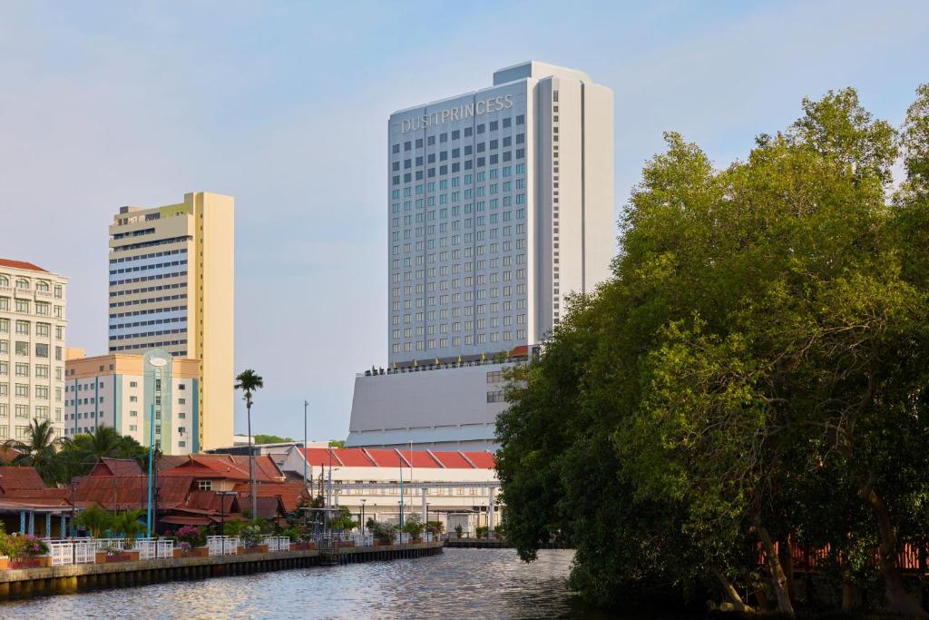 a city with tall buildings next to a river at Dusit Princess Melaka in Malacca