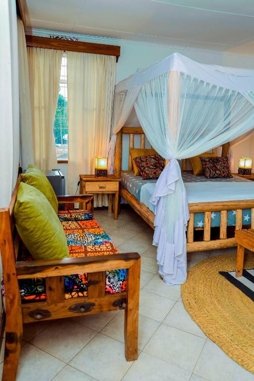 a bedroom with two beds and a canopy bed at City Villa in Arusha