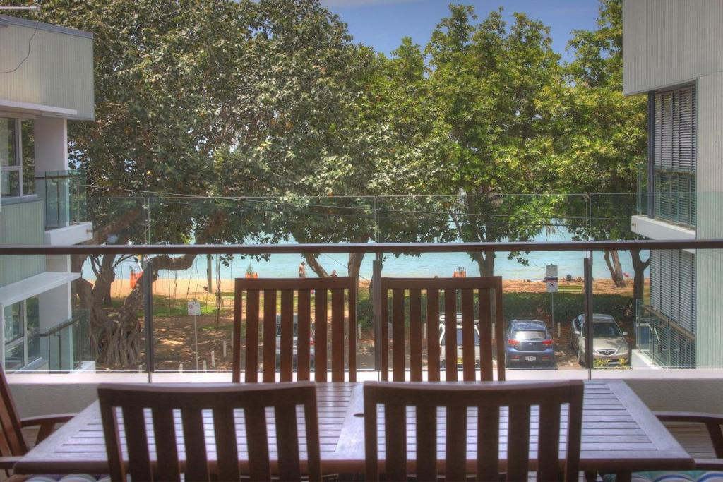 two chairs and a table on a balcony with a view at Maggies Beachfront Apartment 8 in Horseshoe Bay