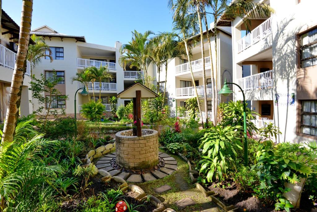 a courtyard with a fountain in front of a building at Uvongo River Resort by MyResorts in Margate