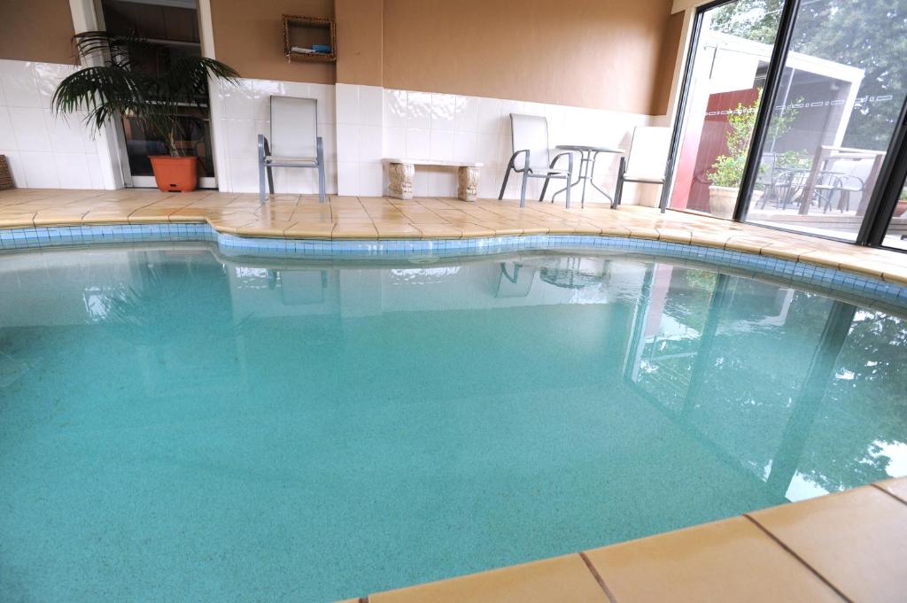 een groot zwembad met blauw water in een gebouw bij Ballarat Central City Motor Inn in Ballarat