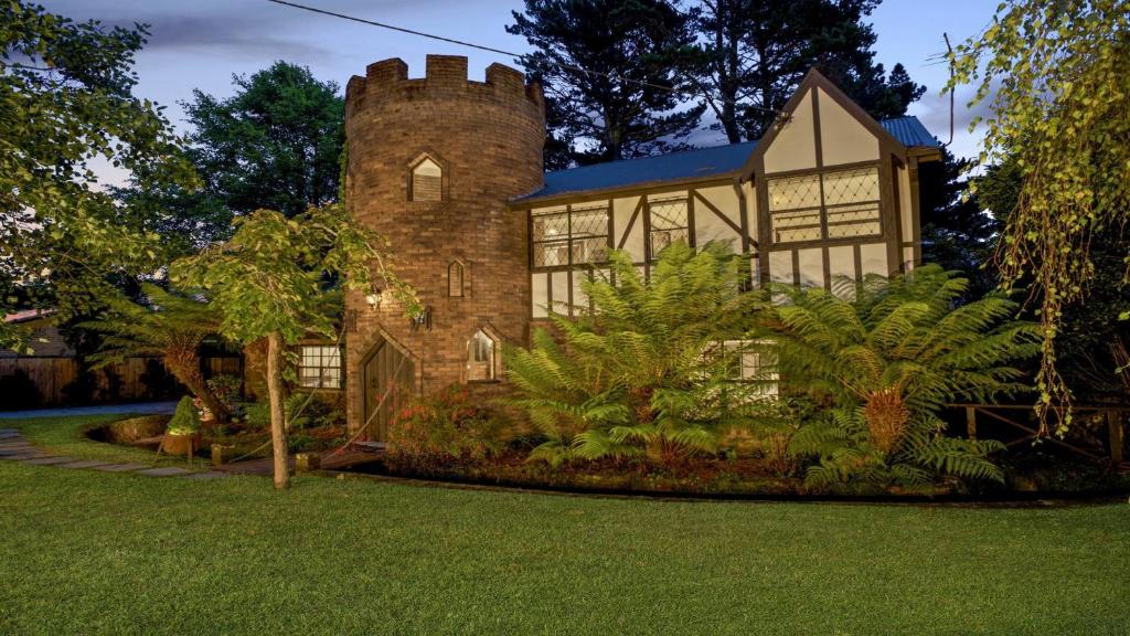 a large brick house with a tower at The Castle Wentworth Falls in Wentworth Falls