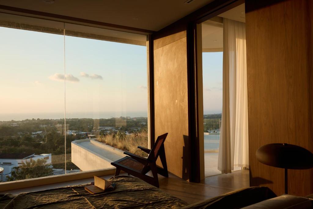 a bedroom with a large window with a view at Fira Uluwatu in Uluwatu