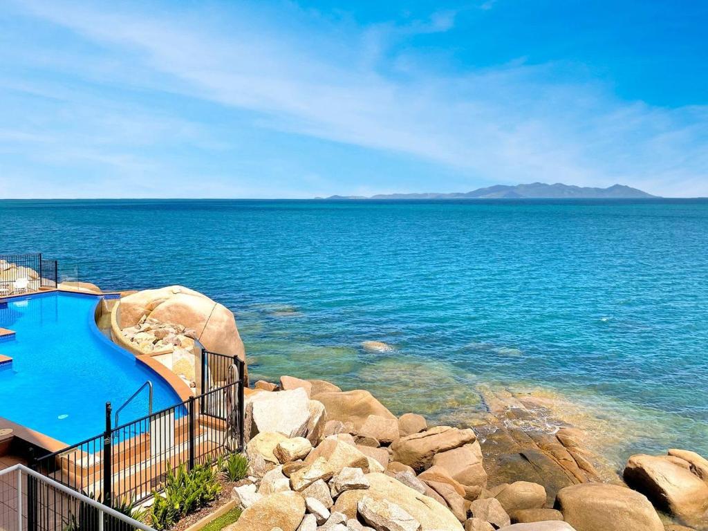 a swimming pool next to a large body of water at 1 Bright Point Apartment 4203 in Nelly Bay