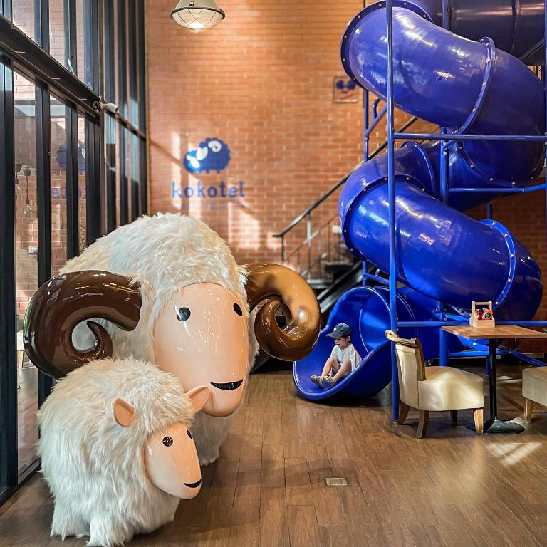 two stuffed animals in a room with a slide at Kokotel Bangkok Surawong in Bangkok