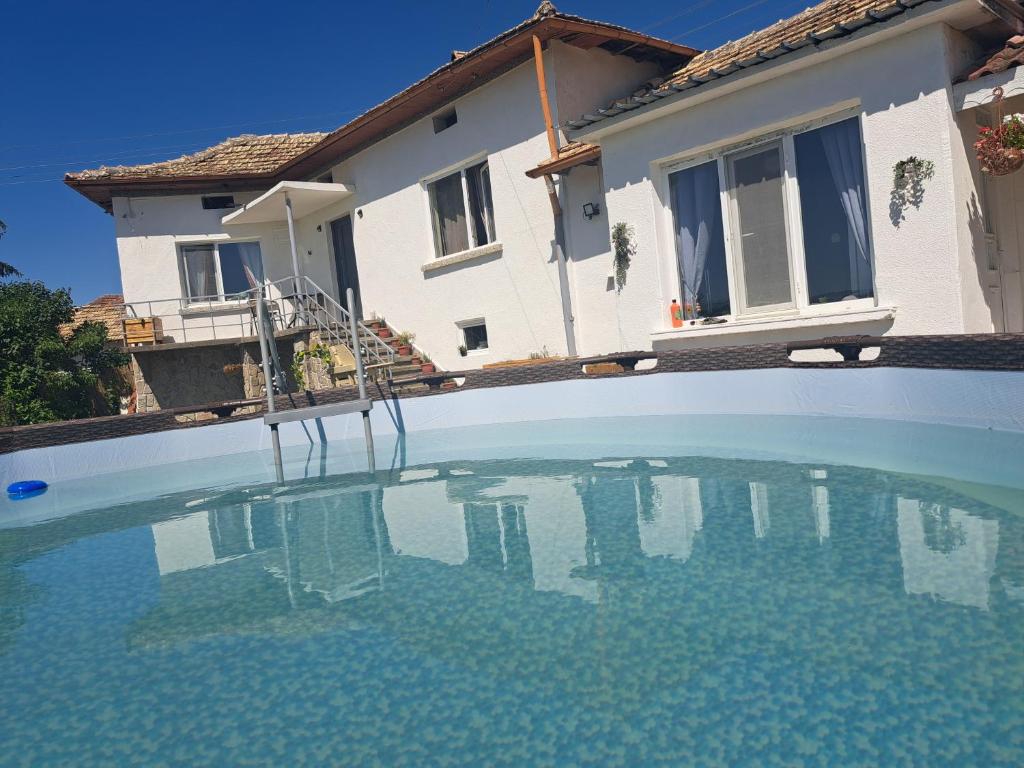 a swimming pool in front of a house at Muddy Puddles Farm in Kovachevets