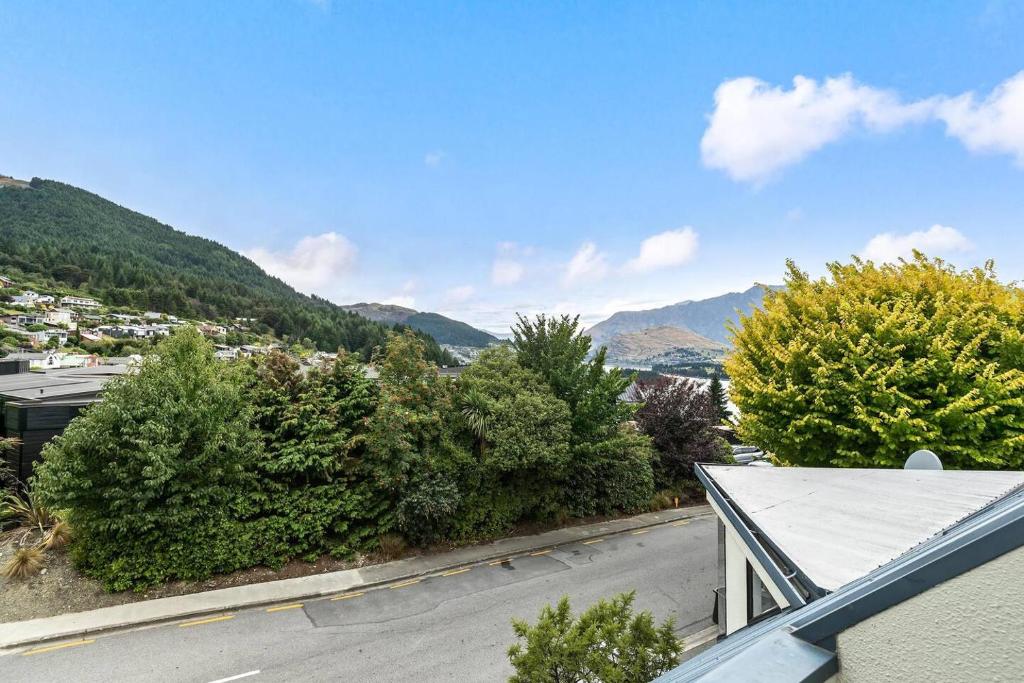 a view of a street with trees and mountains at Sarahs Scenic Stay Mountain Lake Views in Queenstown