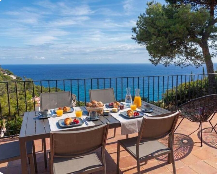 a table with food and a view of the ocean at La Terrasse 1-Vue Mer Panoramique & Piscine, BBQ in Begur