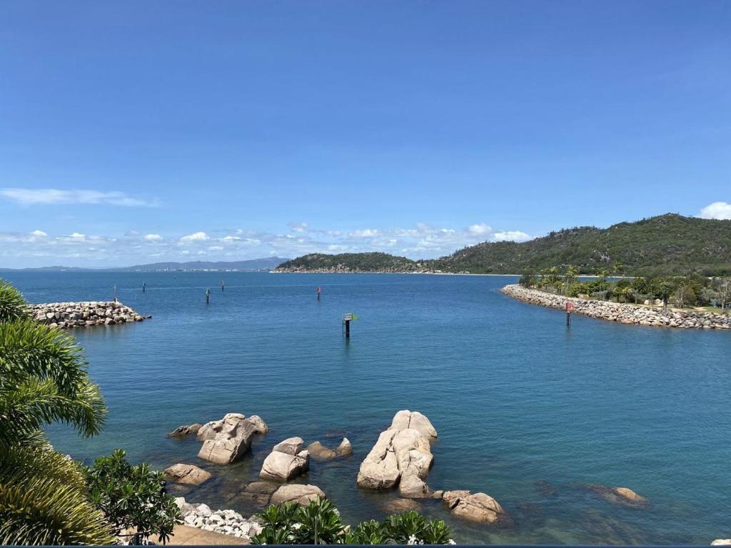 a large body of water with rocks in it at 1 Bright Point Apartment 2303 in Nelly Bay