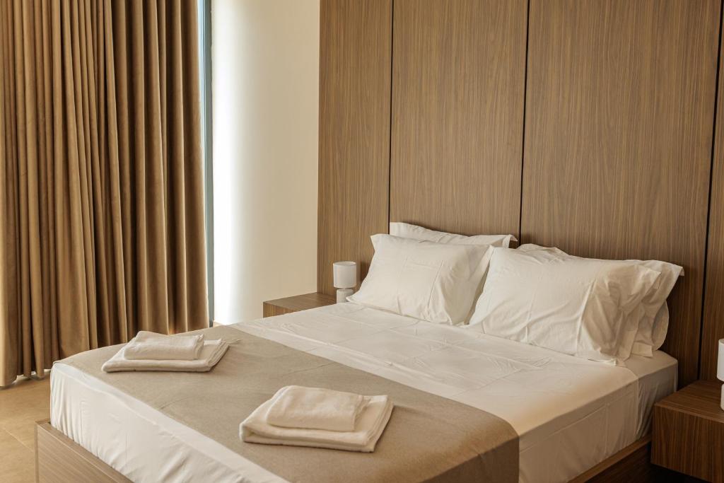 a bedroom with a large bed with two towels on it at Abeille Rooms in Himare