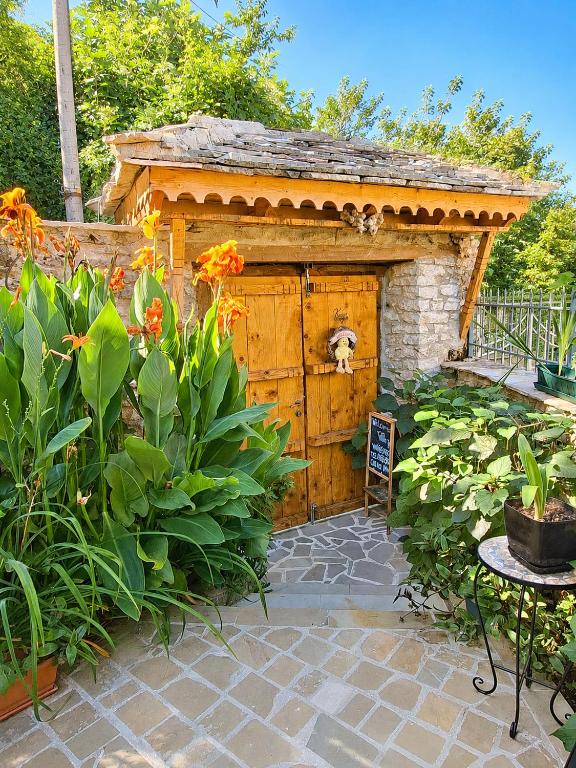a dog is sitting in a shed in a garden at "Villa 70" Guesthouse in Gjirokastër