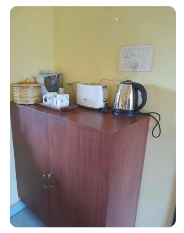 a wooden counter top with a tea kettle on it at Sir Residency in Howrah
