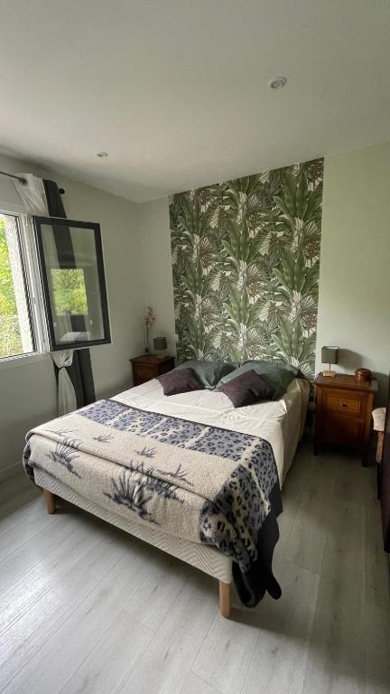 a bedroom with a bed with a floral accent wall at Chez Cathie & Didier in Revel