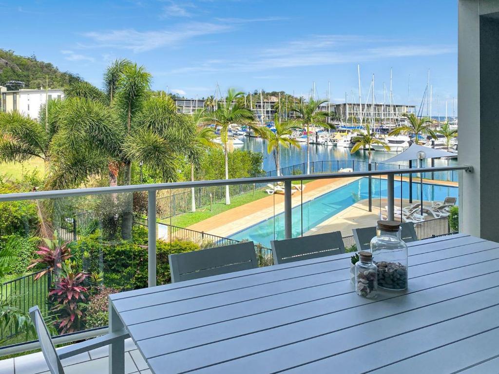a balcony with a table and a view of a marina at Beachside Apartment 14 in Nelly Bay