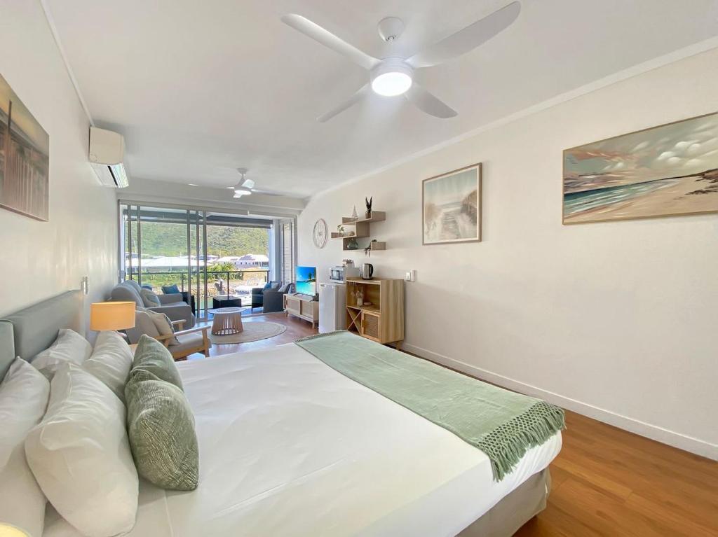 a bedroom with a large bed and a living room at Blue on Blue Studio Room 1222 in Nelly Bay