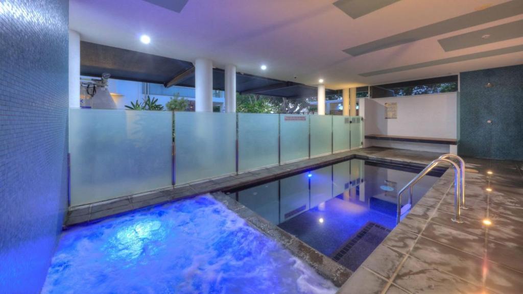 a swimming pool with blue lights in a house at Maggies Beachfront Apartment 10 in Horseshoe Bay