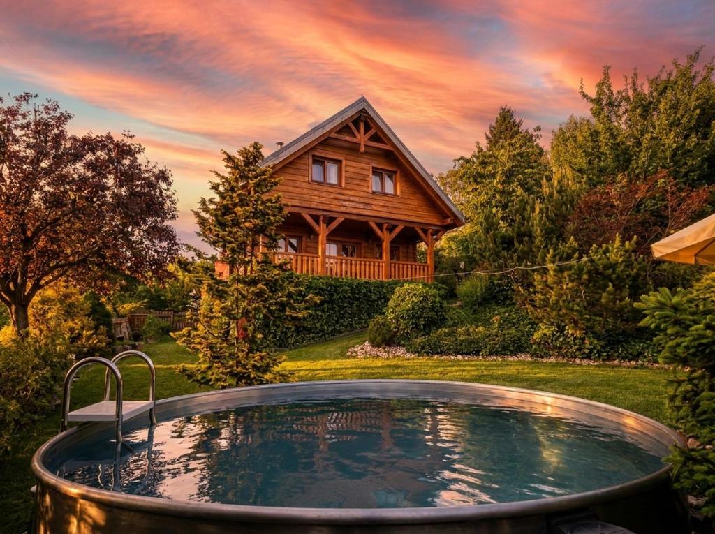 a hot tub in front of a log house at Chalupa u Macochy in Blansko