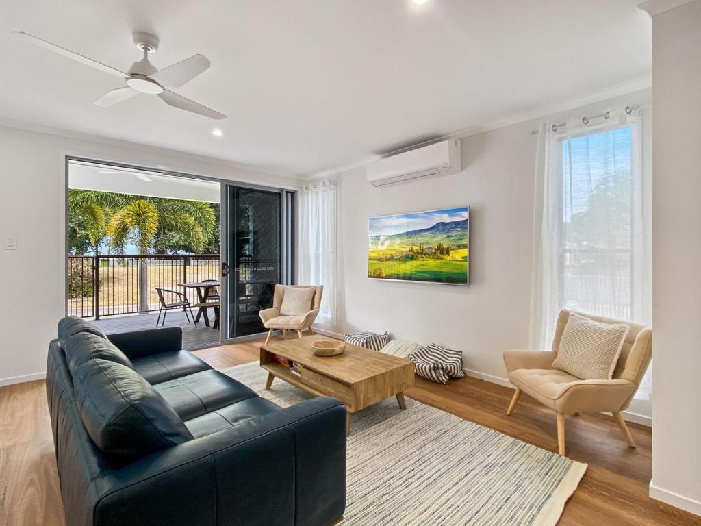 a living room with a black couch and a table at Picnic Point in Picnic Bay