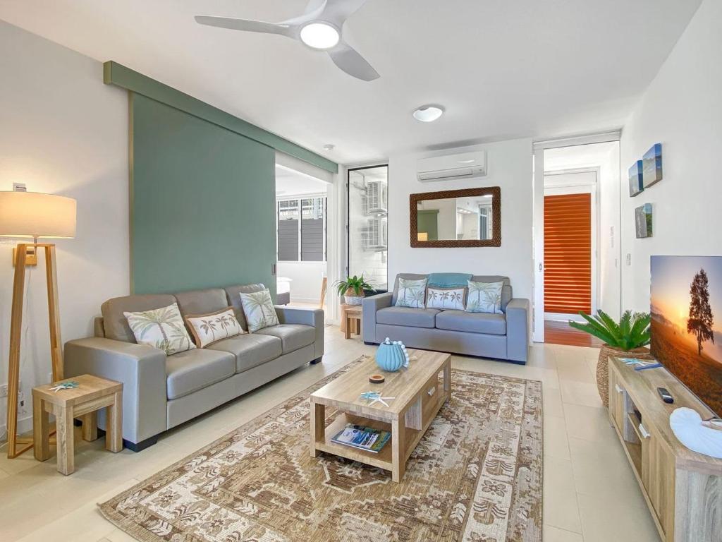 a living room with a couch and a tv at 1 Bright Point Apartment 1407 in Nelly Bay