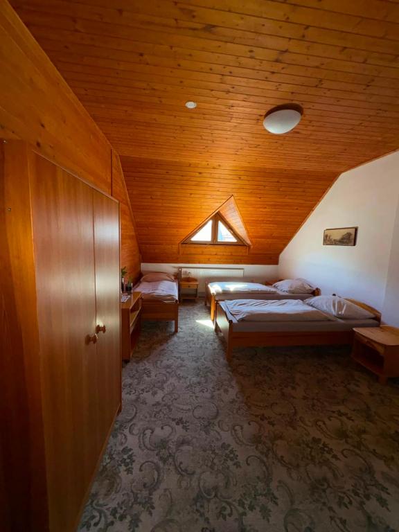 a bedroom with two beds and a wooden ceiling at Hostinec U Havlů in Olomouc