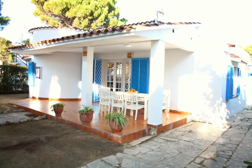 a white house with a table and chairs on a porch at Superb Seafront Villa in Cambrils