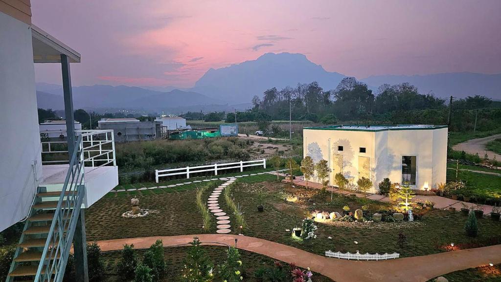 a small house with a mountain in the background at Doi Luang Vista Homestay in Ban Mae To