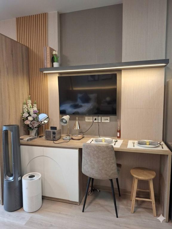 a room with a desk with a television and a chair at Modern Studio Pool View, King bed, BTS Punnawithi in Bangkok