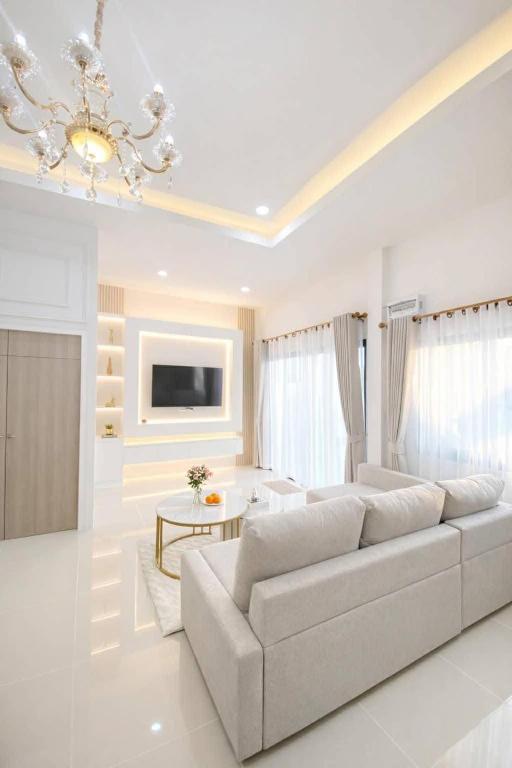 a white living room with a couch and a table at Chill Sbai Villa Pattaya in Nong Prue