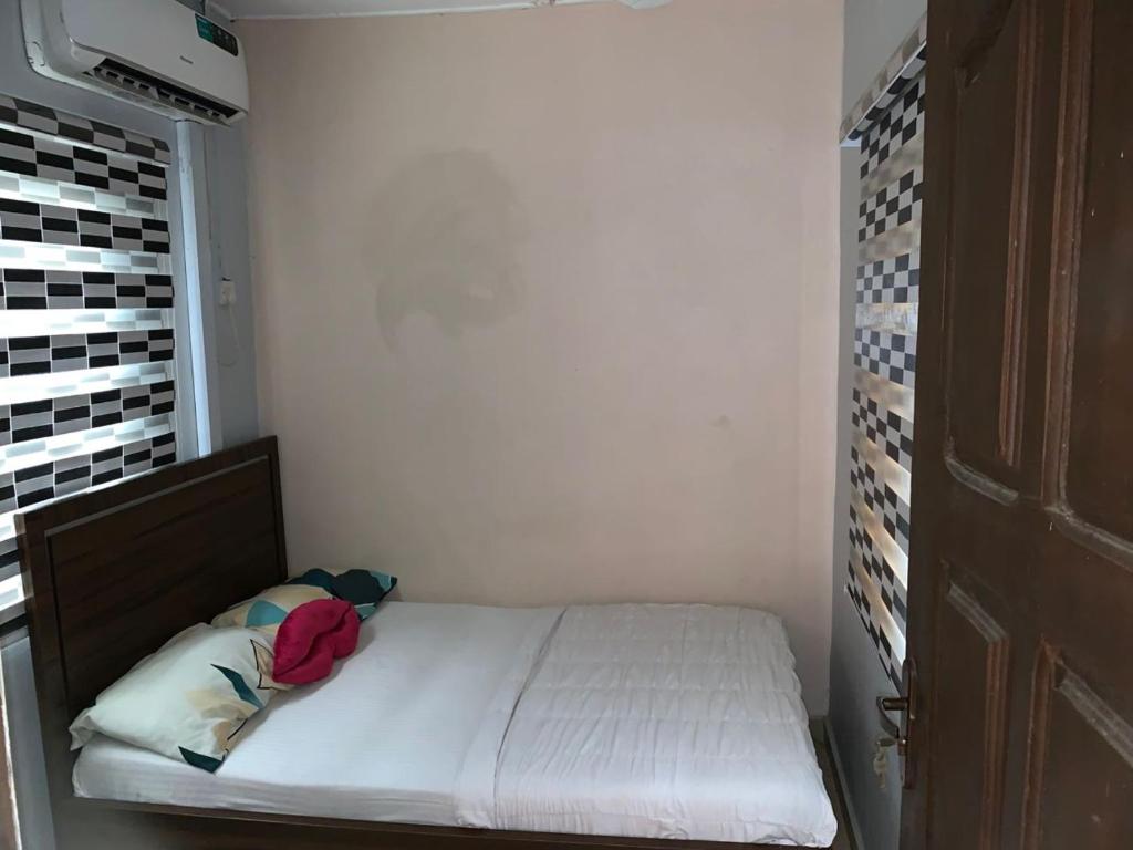 ein kleines Bett in einem kleinen Zimmer mit Fenster in der Unterkunft Prince Ator Hotel in Ikeja