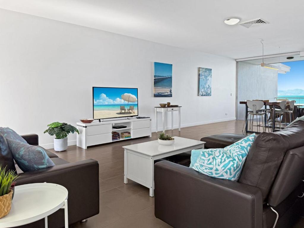 a living room with two couches and a tv at 1 Bright Point Apartment 4501 in Nelly Bay
