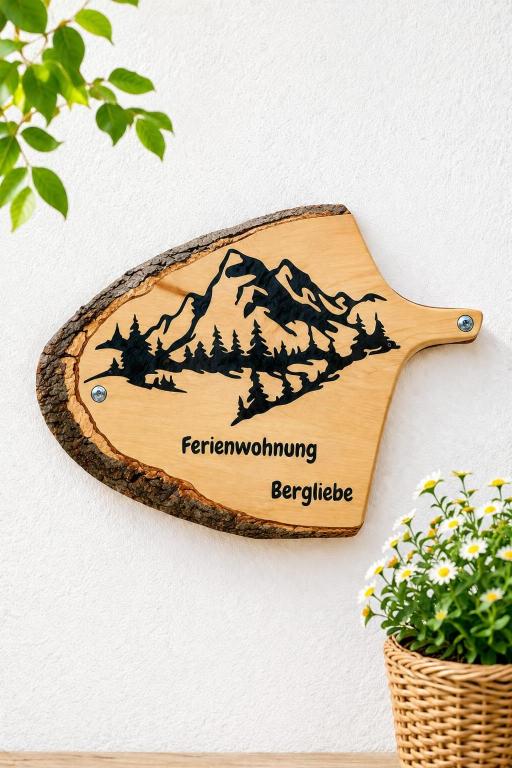 a wooden cutting board with a mountain sign on a wall at Bergliebe - Panoramablick in Saurachberg