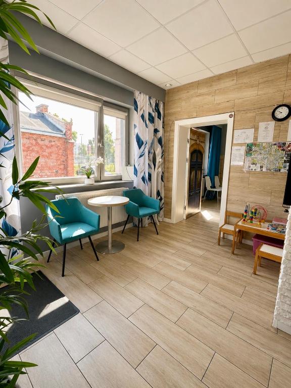 a waiting room with green chairs and a table at Hostel Filip 2 in Gdańsk